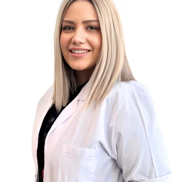 Portrait of Dt. Eda Nur Karademir, a specialist in aesthetic and surgical dentistry, standing in a professional dental clinic setting.