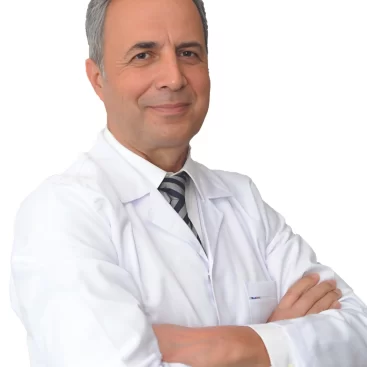 Portrait of Op. Dr. Ergün Erdoğan, a specialist in Ear, Nose, and Throat (ENT) diseases, standing confidently in a medical setting