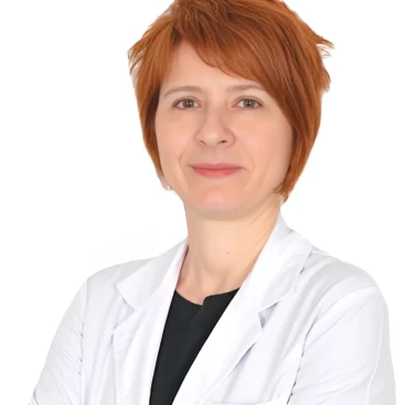 Portrait of Op. Dr. Şefika Aksoy, a Breast Surgery Specialist, standing confidently in a medical setting.