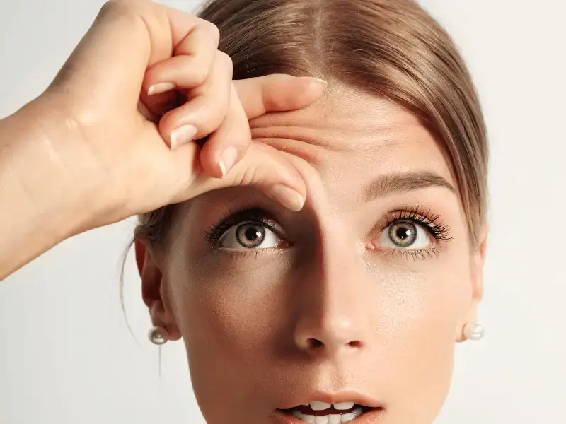 Fox Eye Lift and Canthal Tilt: The Cat-Eye Look Explained A hand lifting the skin above the brow to show how raising the brow tail changes the eye area